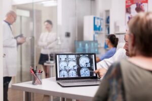 Pediatric neurologist reviewing brain scans using advanced medical technology for treating congenital neurological disorders